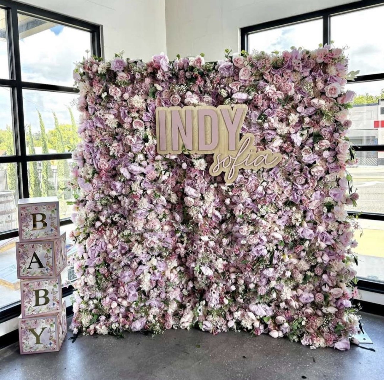 The Mystic flower wall: lilac and pink blooms, with a lettered sign